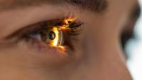 Close up of a light beam shining through the retina and lens of a patient's eye on an eyesight exam.